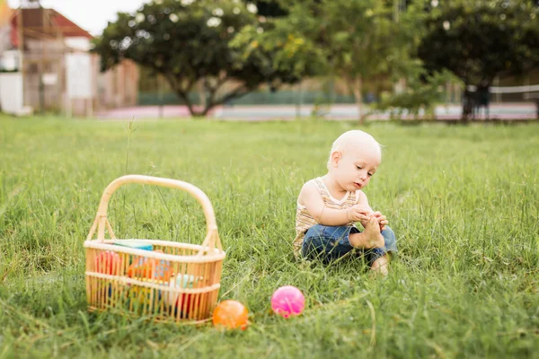 Petit garçon assis sur l'herbe verte — Photo