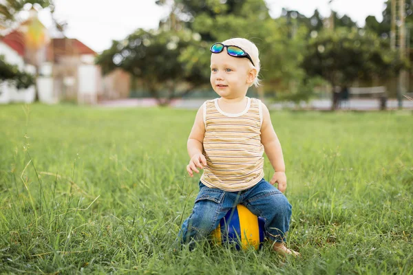 Petit garçon sur l'herbe verte — Photo