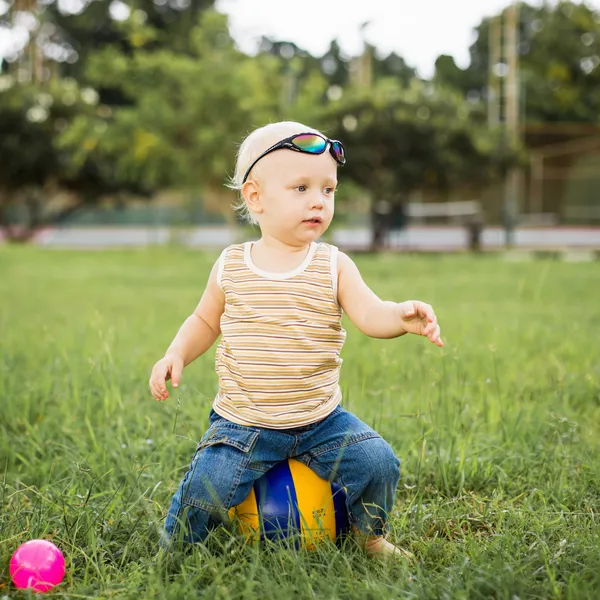 Babyjongen op het groene gras — Stockfoto