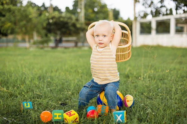Menino brincando em um gramado verde — Fotografia de Stock