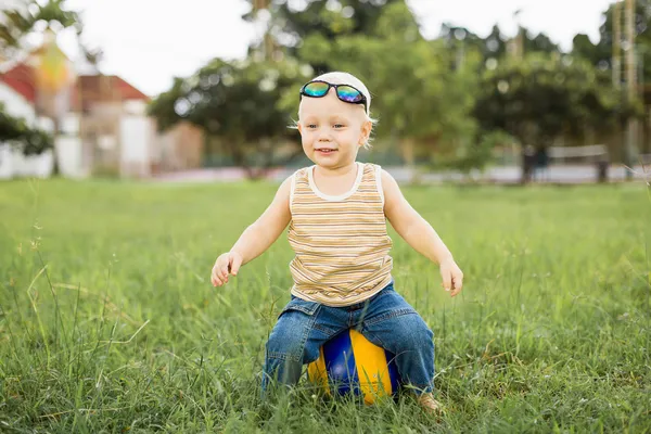 Petit garçon sur l'herbe verte — Photo