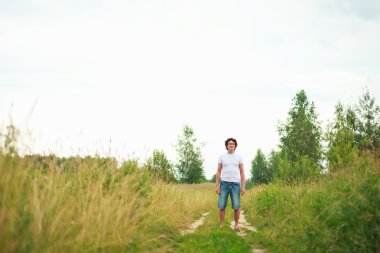 çimlerde oturan bir genç adam