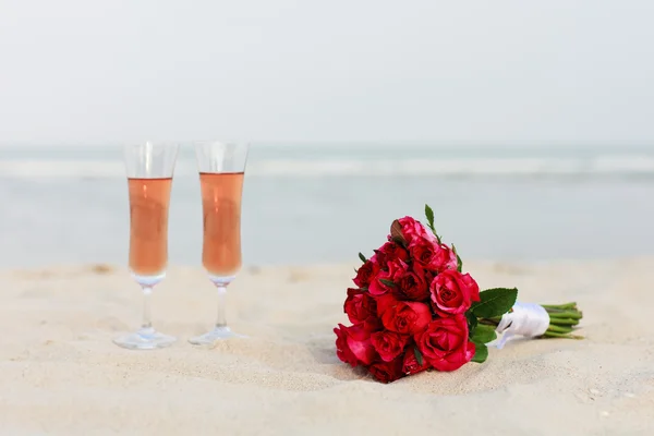 Ramo nupcial de rosas rojas en una playa — Foto de Stock