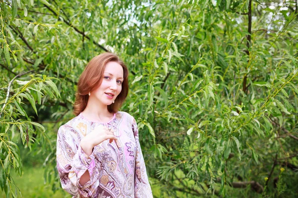 Woman on a background of green trees — Stock Photo, Image