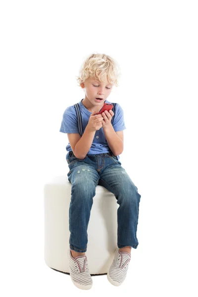 Rapaz com um telemóvel vermelho — Fotografia de Stock