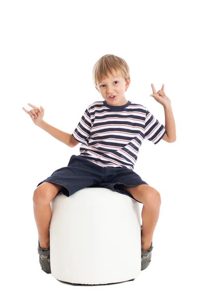 Çocuk beyaz bir sandalyede oturuyor — Stok fotoğraf