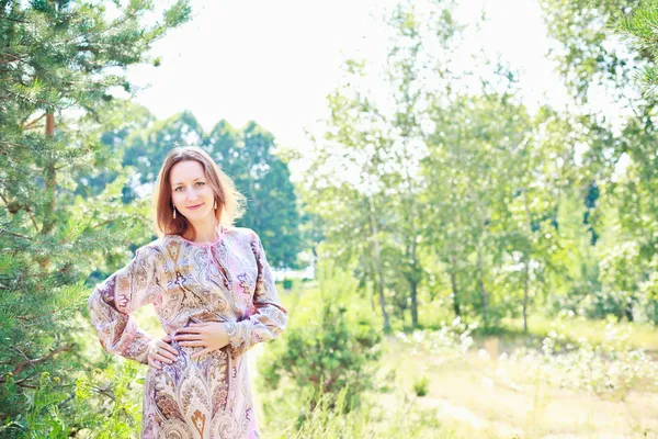 Vrouw op een achtergrond van groene bomen — Stockfoto