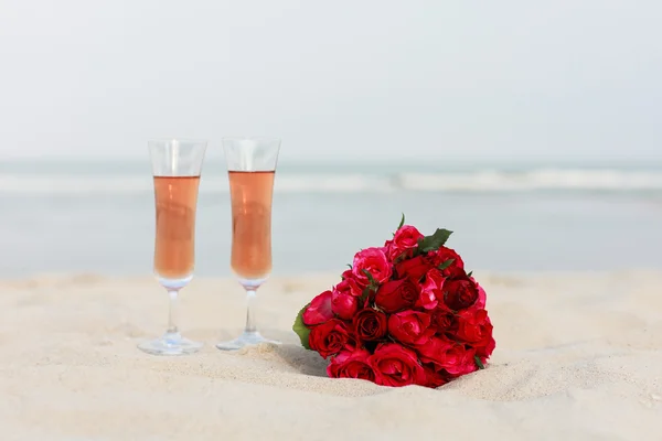 Ramo nupcial de rosas rojas en una playa — Foto de Stock