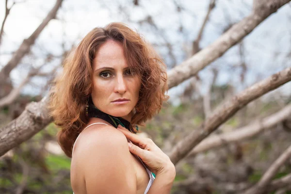 Mujer sobre un fondo de árboles secos — Foto de Stock