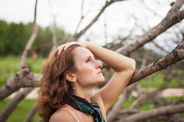 Woman on a background of dry trees — Stock Photo, Image