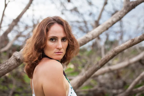 Mujer sobre un fondo de árboles secos — Foto de Stock