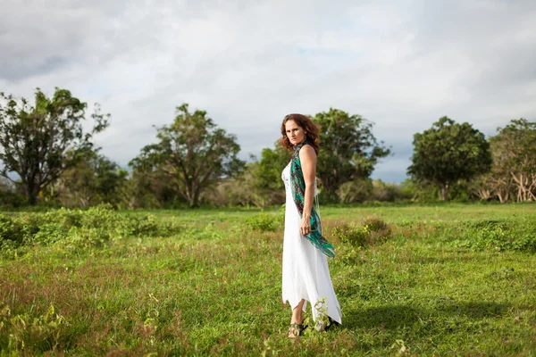 Mujer caminando en el campo verde — Foto de Stock