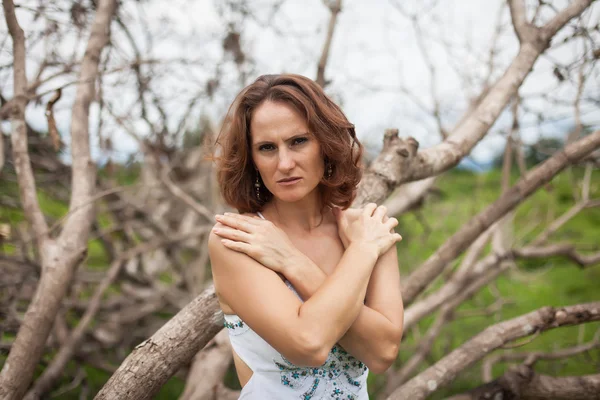 Женщина на фоне сухих деревьев — стоковое фото