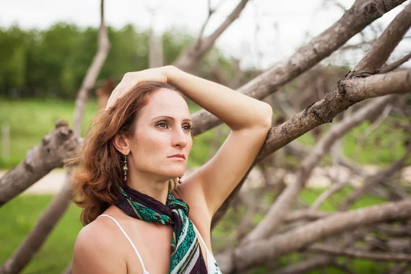 Woman on a background of dry trees — Stock Photo, Image