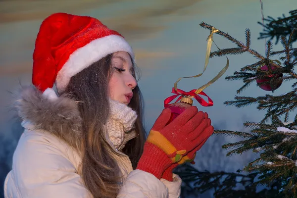 Девушка дует на рождественские украшения — стоковое фото