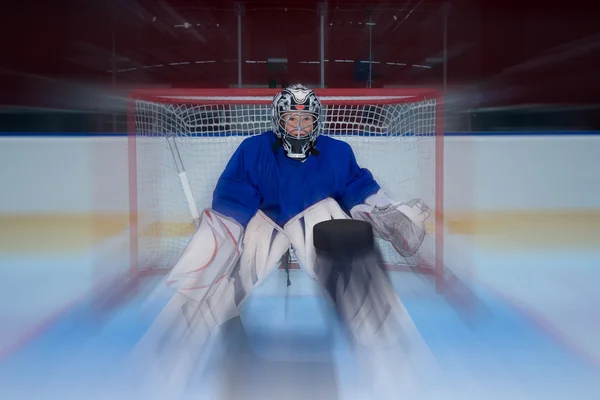 Jeune gardien de hockey et rondelle volante — Photo