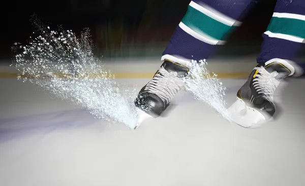 Eis funkelt unter Eishockeyschuhen lizenzfreie Stockbilder