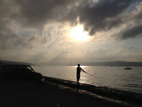 Men fishing in sunset — Stock Photo, Image