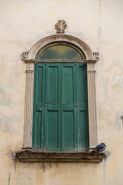 Classic window with green shutters in Padua, Veneto, Italy.