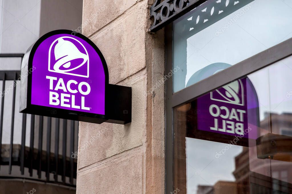 Seville, Spain-FEB 24, 2022: The entrance and the signboard with logo of Taco Bell in Seville, Spain. American chain of fast food restaurants originating in Irvine, California.