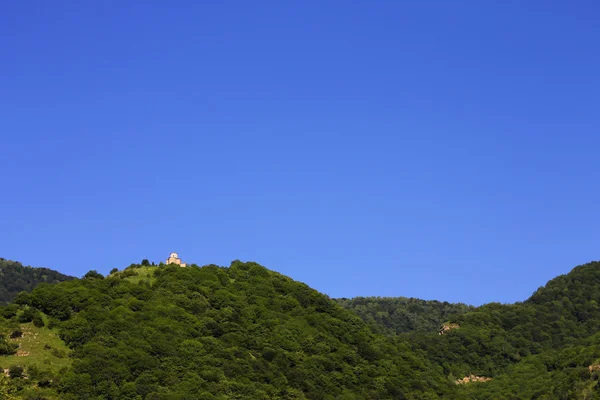 Osamělý vzdálený klášter na vrcholu hory — Stock fotografie