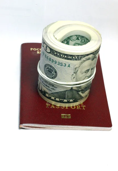 Pilha de papel EUA dólares sobre o passaporte vermelho — Fotografia de Stock