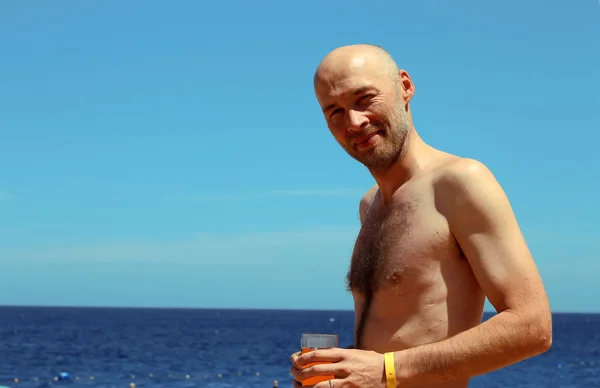 Homem com dois copos de bebidas e fundo do mar Vermelho — Fotografia de Stock