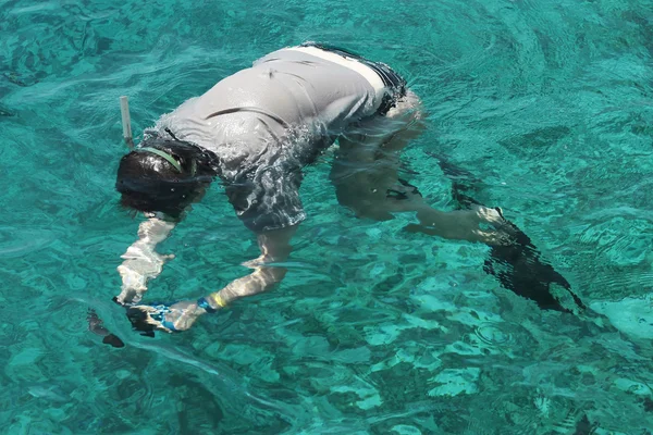 Woman photographer diving into water of Red sea — Zdjęcie stockowe