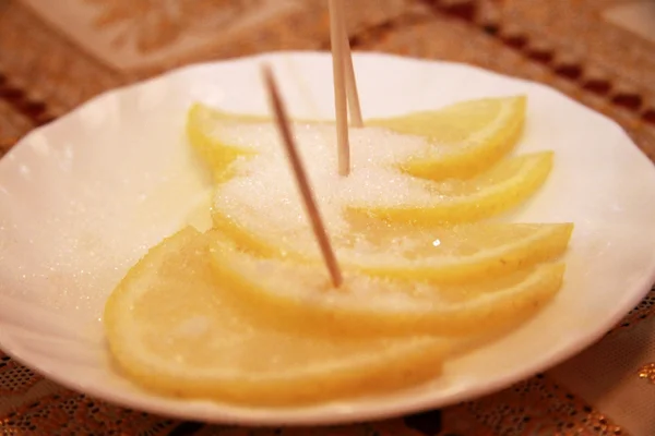 Свіжий лимон на білій тарілці з цукром — стокове фото