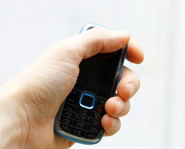 Чорно-синій мобільний телефон в руці чоловіка ізольований — стокове фото