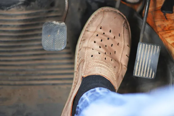 Mans voeten duwen op het gaspedaal van de auto — Stockfoto