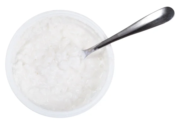 Spoon in tub of cottage cheese — Stock Photo, Image