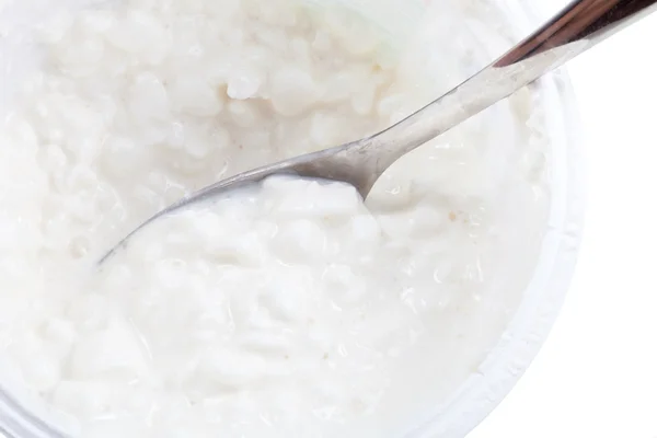 Spoon in tub of cottage cheese — Stock Photo, Image