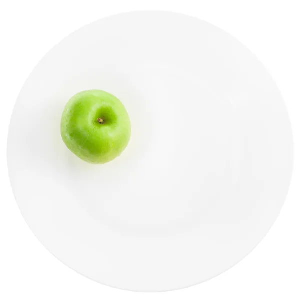 Green apple on white plate — Stock Photo, Image