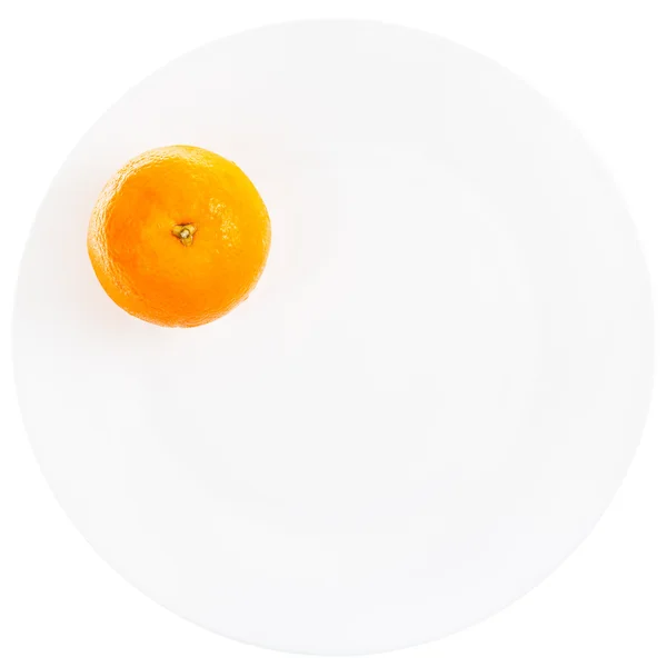 Ένα πορτοκαλί σε λευκό πιάτο — Φωτογραφία Αρχείου
