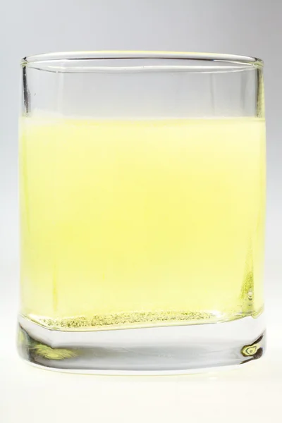 Glass of yellow carbonated water — Stock Photo, Image