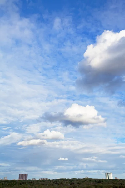 Verschillende witte cumulus wolken onder stad — Stockfoto