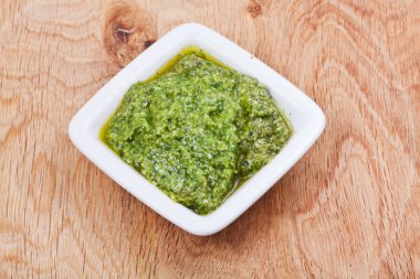 ahşap tahta üzerinde taze pesto ile kase