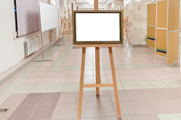 Marco de madera dorada en caballete en sala de galería de arte —  Fotos de Stock