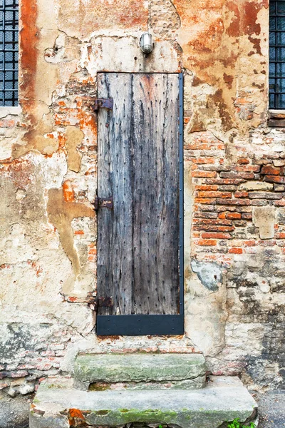 Puerta de madera en pared de ladrillo de mala calidad —  Fotos de Stock