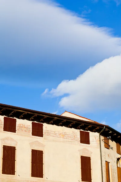 Witte wolken in blauwe hemel onder middeleeuwse huis — Stockfoto