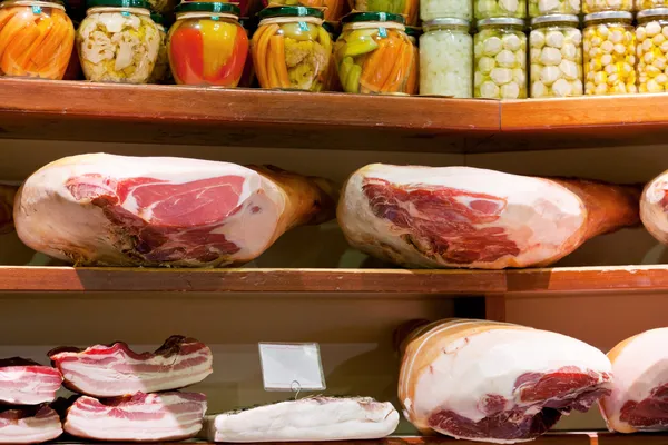 Hams e bacon salgado em pequena loja local — Fotografia de Stock