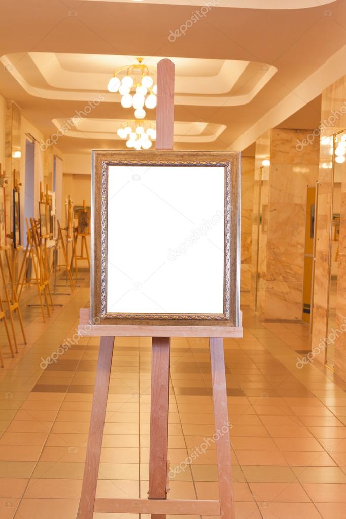 Wooden picture frame on easel in art gallery