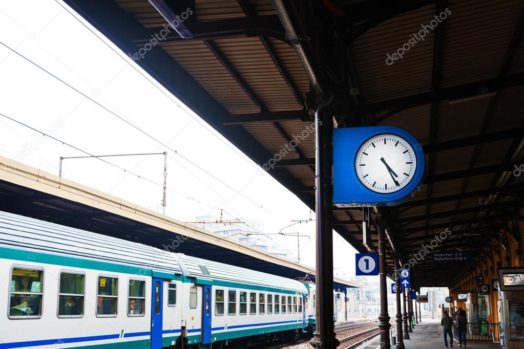 Outdoor clock on railway platform and train