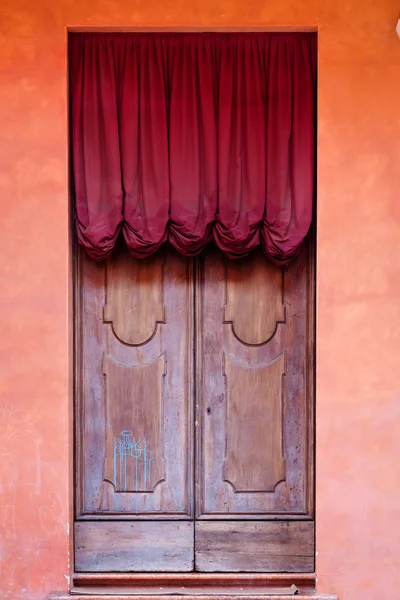 Ortaçağ evinin kırmızı perde ile ahşap kapı — Stok fotoğraf