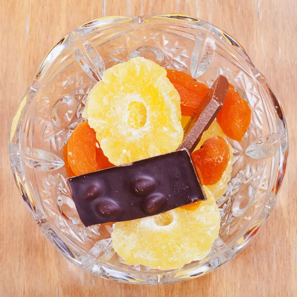 Dried fruits and chocolate in glass bowl — Stock Photo, Image
