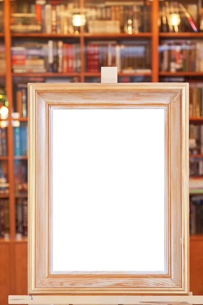 Weiße Leinwand aus breitem Bilderrahmen auf Staffelei in der Bibliothek — Stockfoto