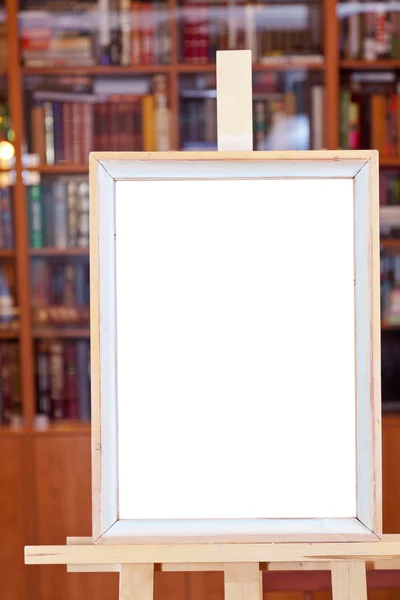 Witte doek van eenvoudige afbeeldingsframe op ezel in bibliotheek — Stockfoto