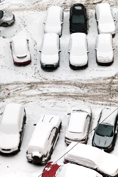 Вид сверху автомобилей, засыпанных снегом на парковке — стоковое фото