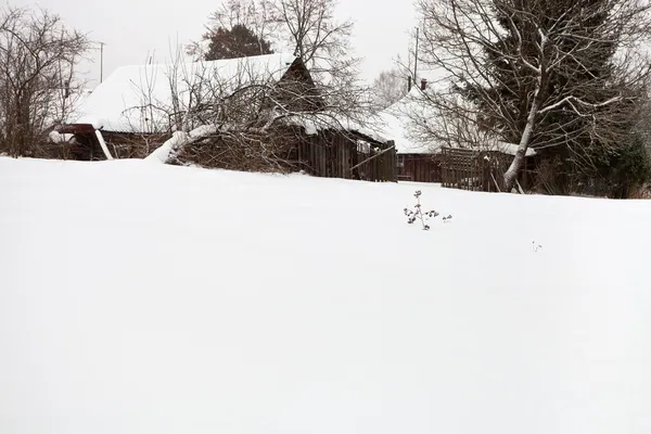 Casas rústicas de madera cubiertas de nieve en el pueblo —  Fotos de Stock